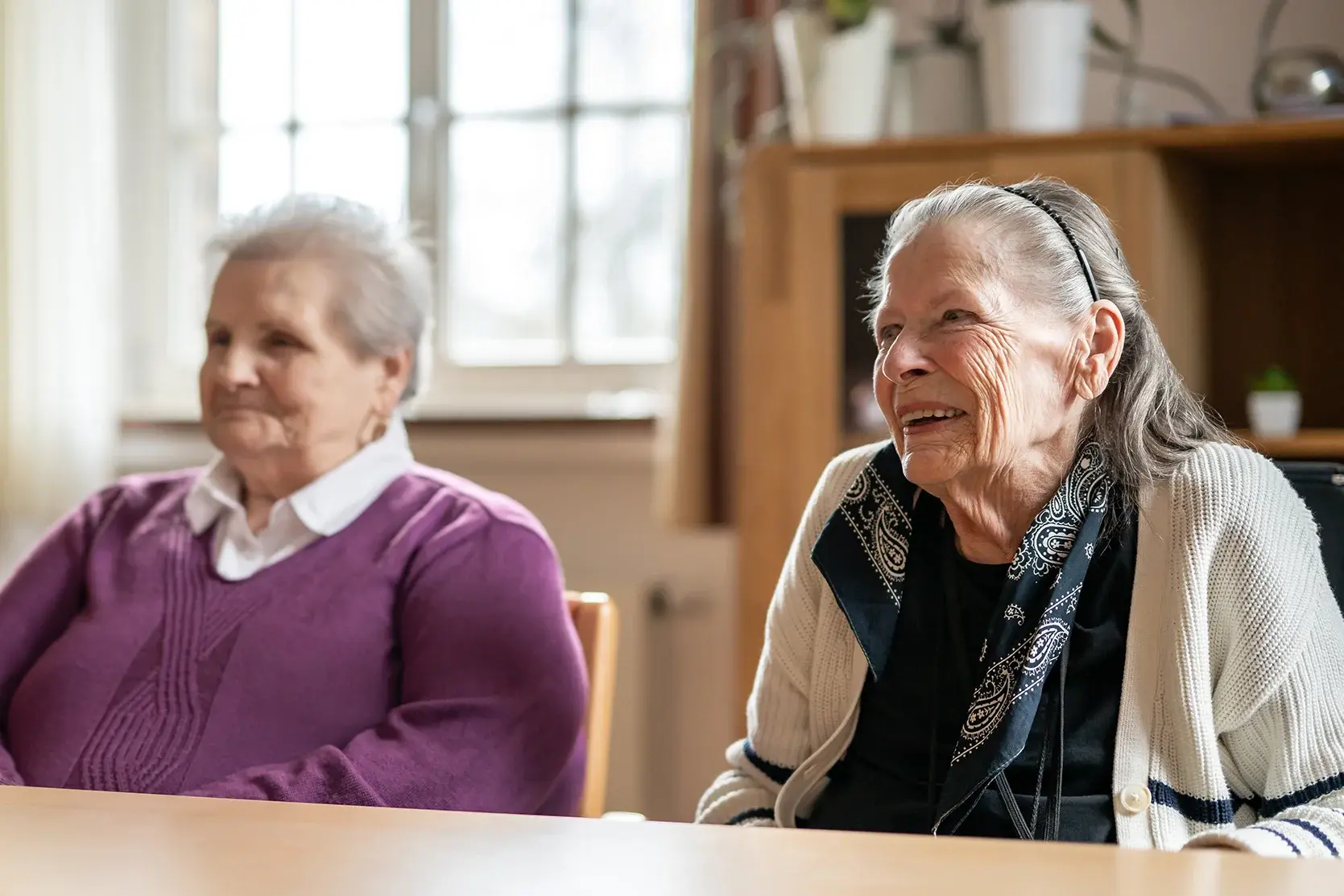 Bund der Caritasstiftungen im Bistum Hildesheim BdC: Zwei Seniorinnen sitzen an einem Tisch in einem Raum