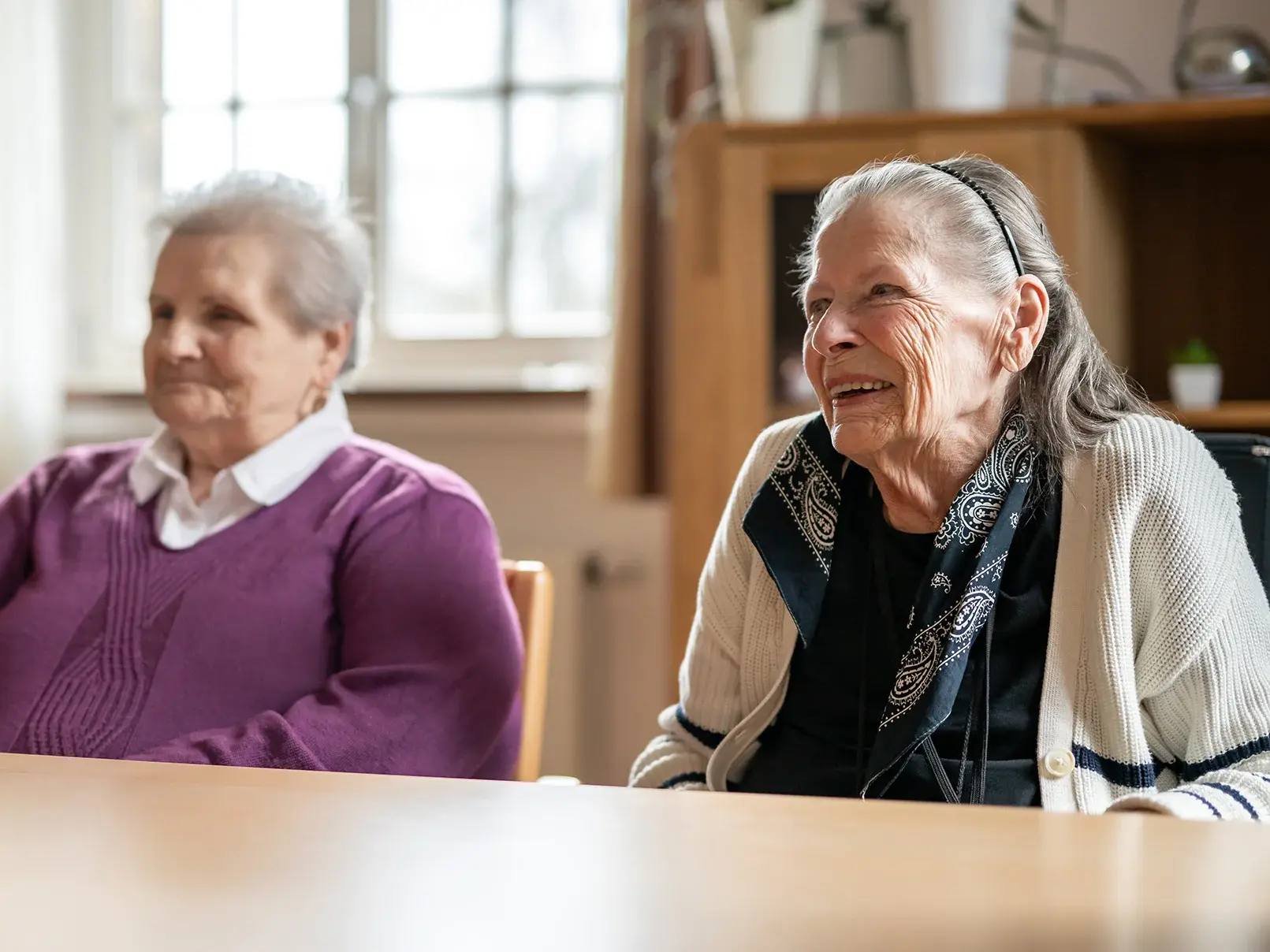 Bund der Caritasstiftungen im Bistum Hildesheim BdC: Zwei Seniorinnen sitzen an einem Tisch in einem Raum