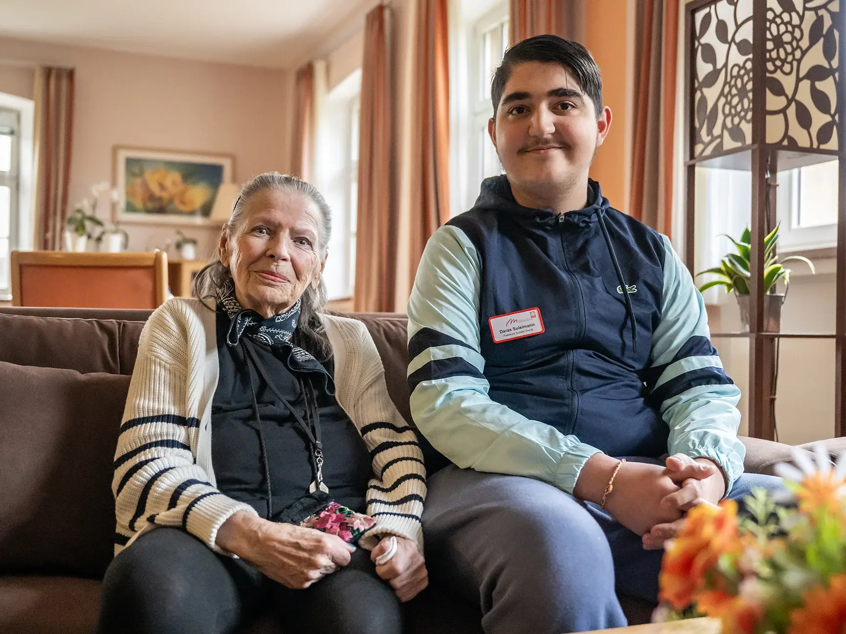 Bund der Caritasstiftungen im Bistum Hildesheim BdC Seniorenhilfe: Ehrenamtlicher Helfer sitzt mit Seniorin auf Sofa