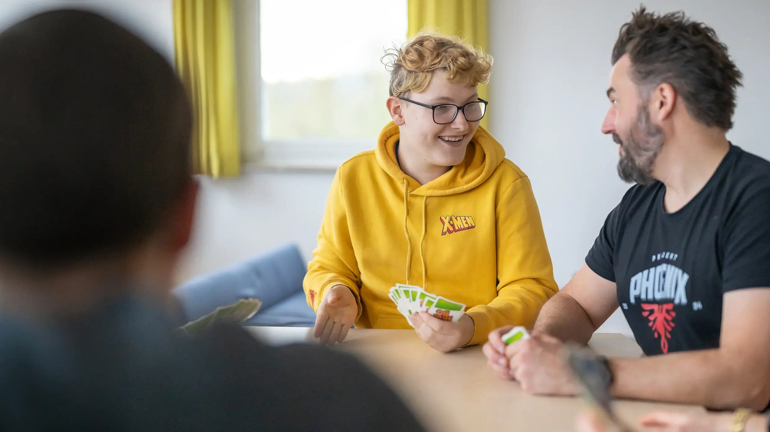 Bund der Caritasstiftungen im Bistum Hildesheim BdC Kinder- und Jugendhilfe: Jugendlicher und Sozialarbeiter spielen Karten
