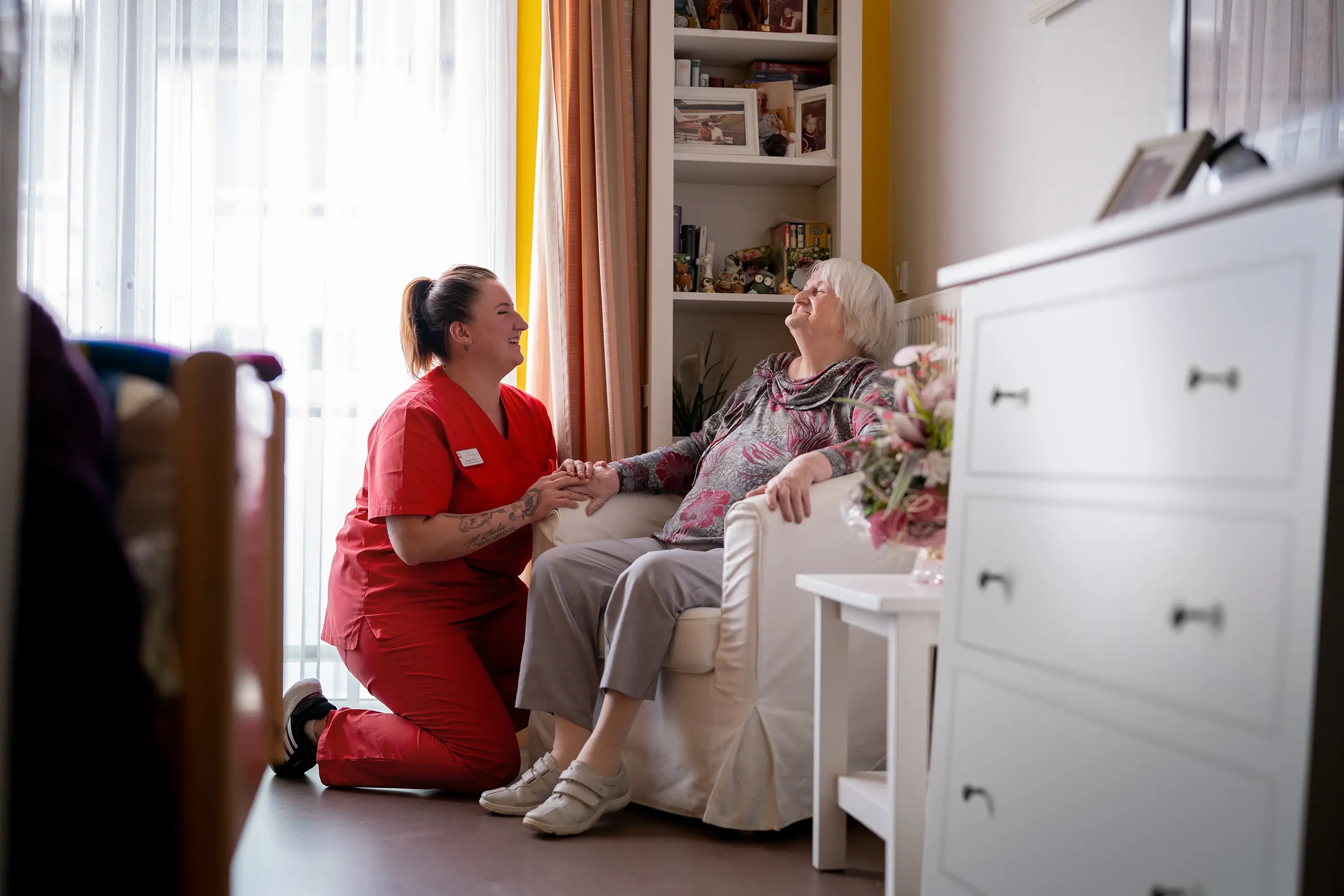 BdC Seniorenhilfe: Pflegekraft hält die Hand einer Seniorin