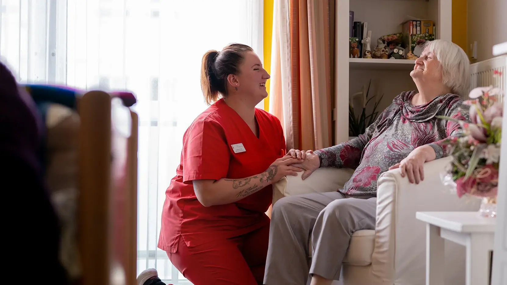 BdC Seniorenhilfe: Pflegekraft hält die Hand einer Seniorin