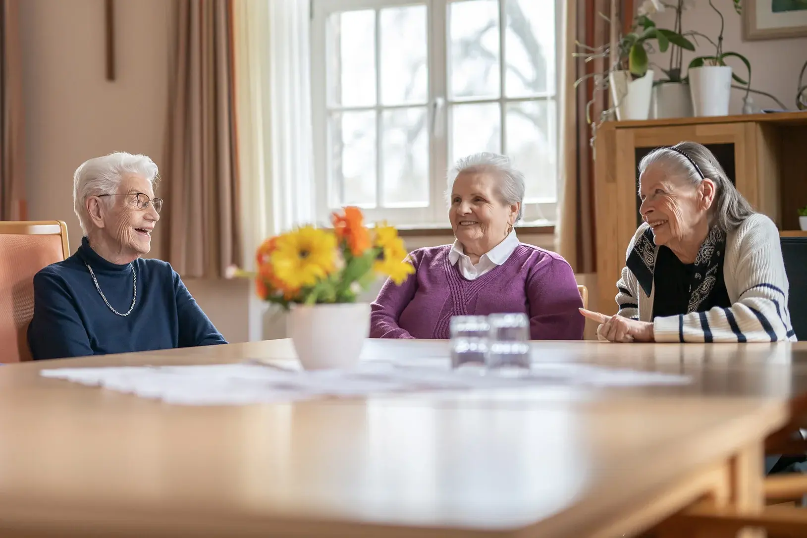 Bund der Caritasstiftungen im Bistum Hildesheim BdC Seniorenhilfe: Seniorinnen sitzen an einem Tisch und lachen